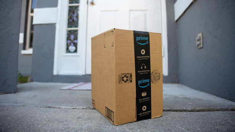 Amazon box with Prime labeling on the front steps of a residential home