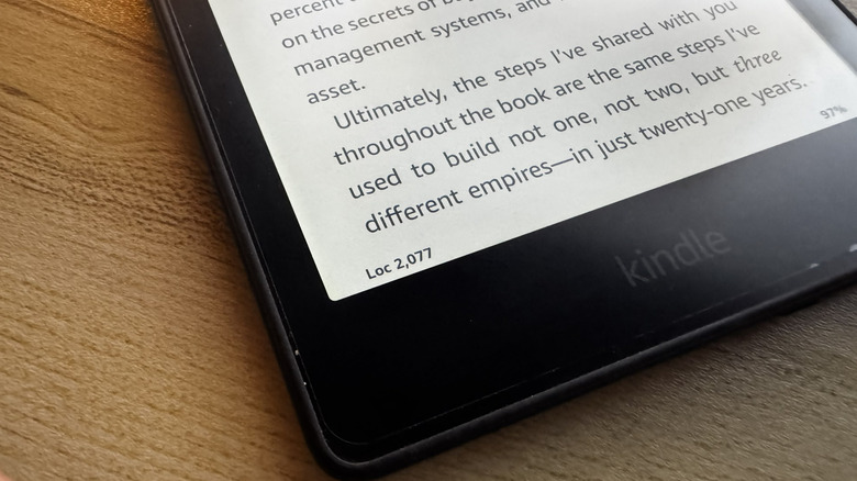 A Kindle on a wooden surface showing the Loc number at the bottom
