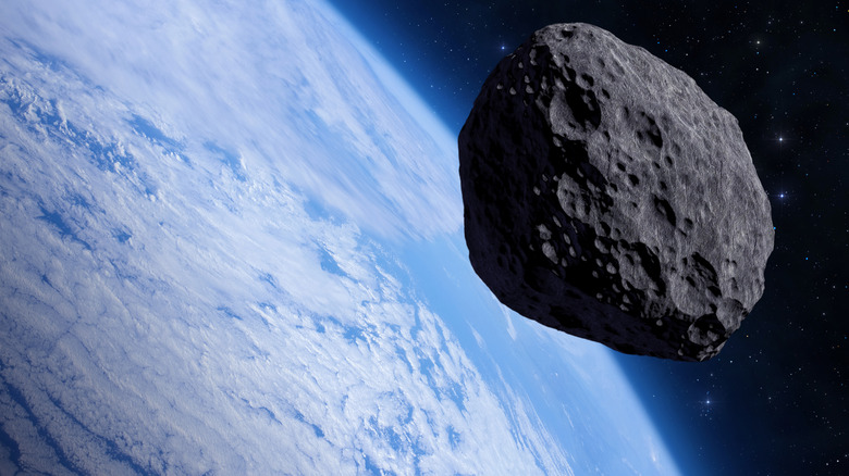 Big asteroid in space with blue planet Earth in the background.