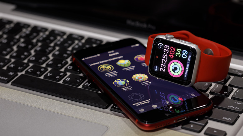Close-Up of the iPhone SE 2nd gen and a Silver Apple Watch with a red band