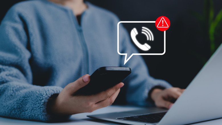A person working on their laptop, interrupted by a phone ringtone
