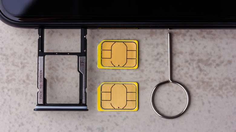 Opening the SIM card and SD card tray on a smartphone.