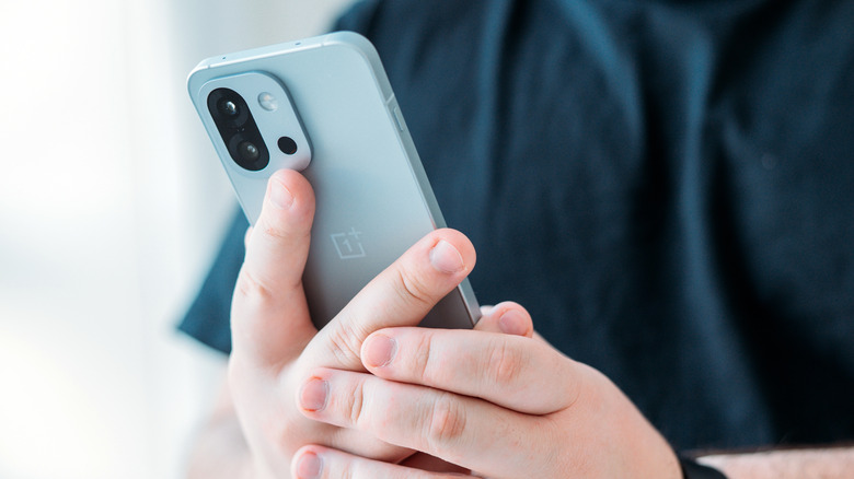 Person holding a OnePlus 13T phone.