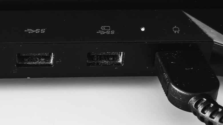 Close-up of a laptop side showing different USB ports