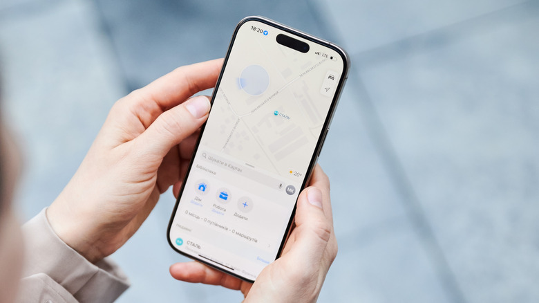 Hands holding an iPhone with Apple Maps running