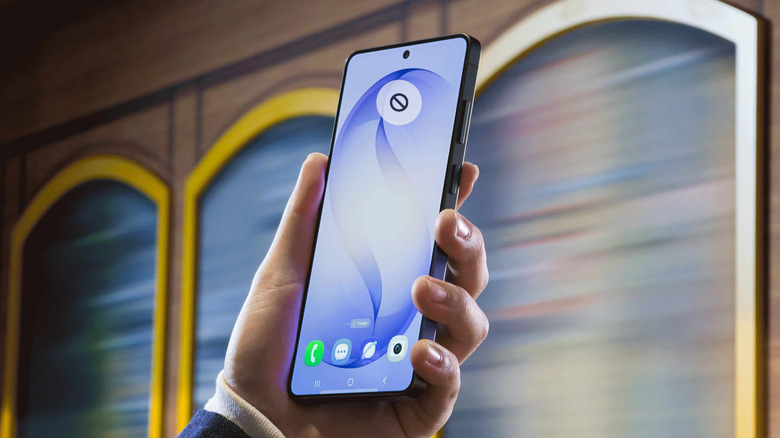 Close-up of a person holding a Samsung Galaxy S26 Ultra with a superimposed no signal icon