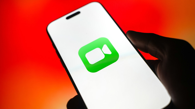 Apple FaceTime logo on an iPhone screen on a red and orange background