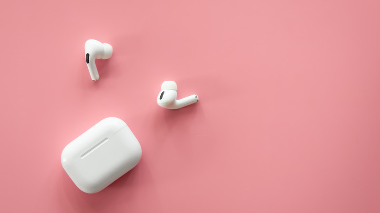 The AirPods Pro and charging case set against a pink backdrop.