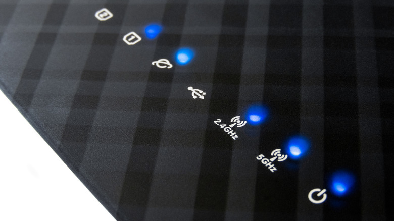 Blue indicator lights on a wireless router with symbols visible.