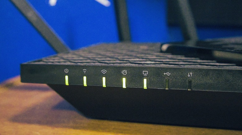 TP-Link router indicators with green lights visible on the front.