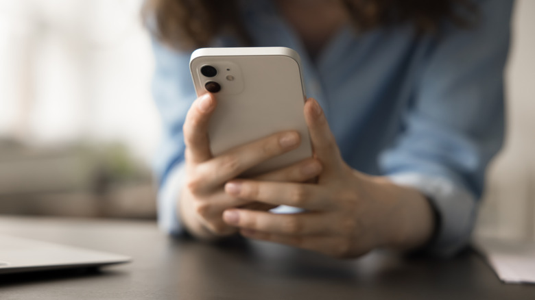Woman holding a white smartphone