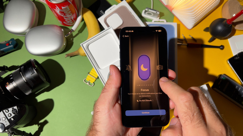 A person starting Focus mode on an iPhone from the Action button.