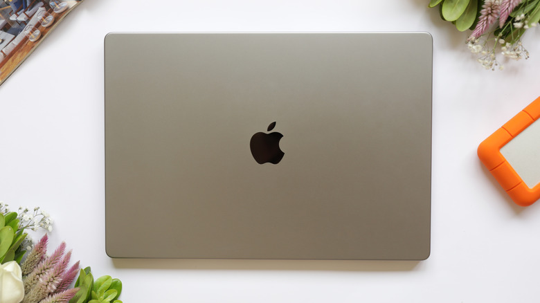 Apple MacBook Air 13 cover on a white desk, table with hard disc, flowers and magazine.