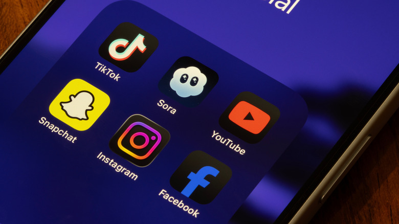 ssorted social apps, including TikTok, Sora, YouTube, Snapchat, Instagram, and Facebook, are seen on the screen of an iPhone.