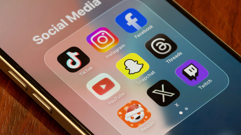Assorted apps (TikTok, Instagram, Facebook, YouTube, Snapchat, Threads, Reddit, X, and Twitch) included in Australia's world-first teen social media ban are seen on the screen of an iPhone.