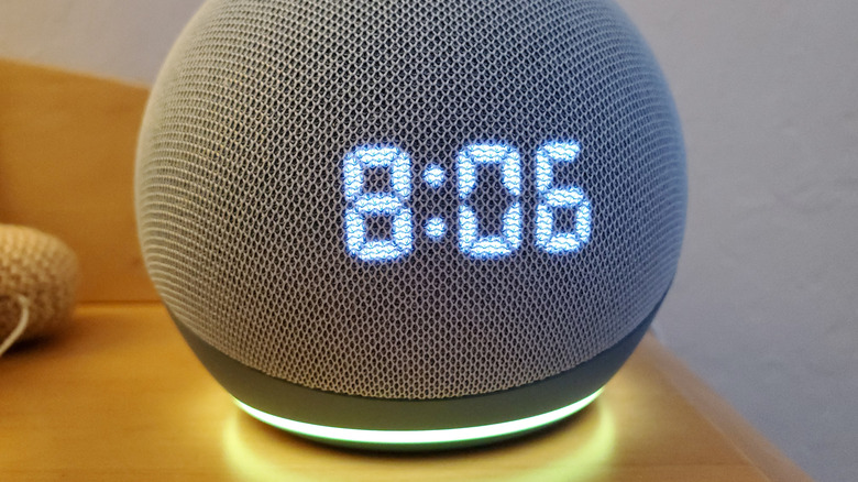 An Amazon Echo Dot with Clock displaying a yellow or green light.