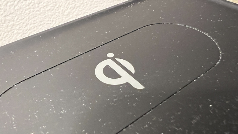 Close-up of a Qi wireless charging symbol on a black surface