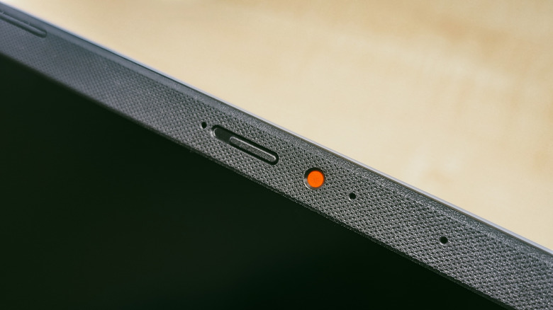 laptop placed on a table with a webcam featuring a privacy shutter and a red dot on the side