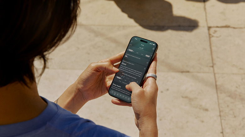 Person wearing Oura ring and using app