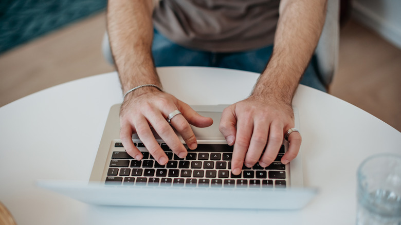An overhead images of two male hands typing on a keyboard.