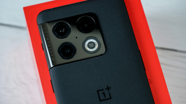 An image of a OnePlus 10 Pro G in front of a red case