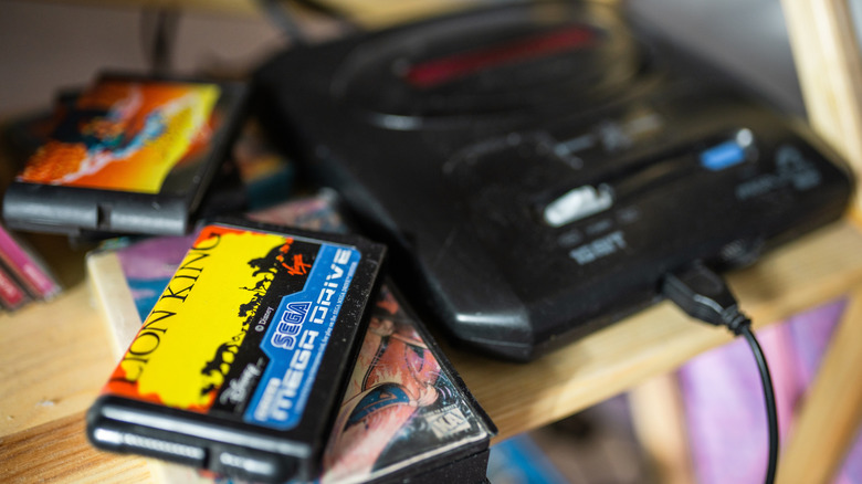 Close-up of retro Sega console with games