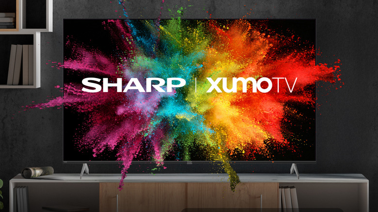 A TV is placed on top of a TV stand in a modern living room. A Sharp | Xumo TV logo is shown.