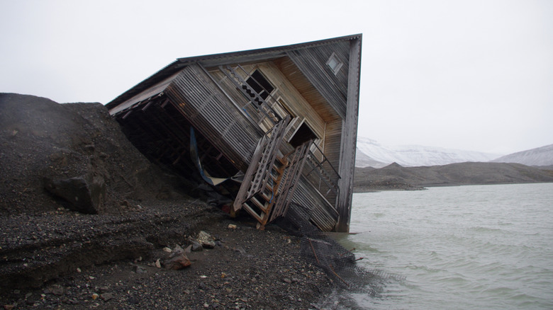 House sinking into the water because of melting permafrost