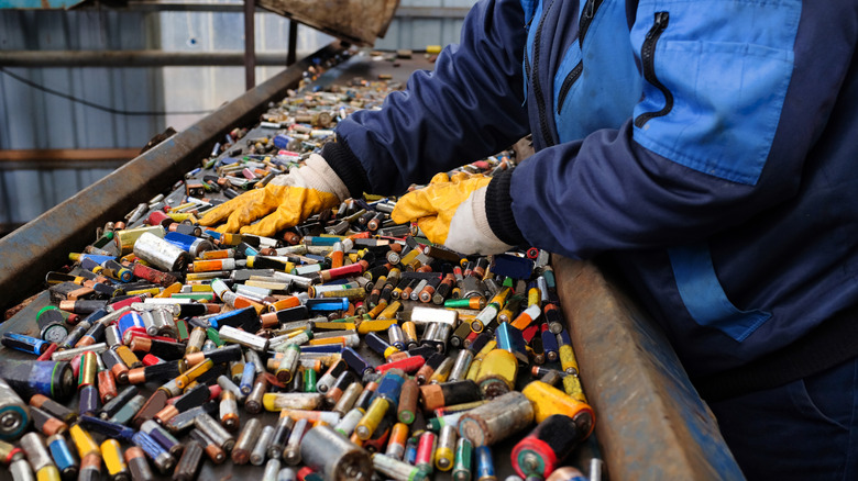 A recycling facility worker sorts batteries.