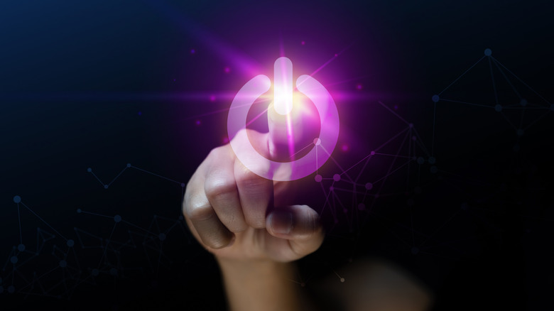 concept of floating power button with hand behind it, pressing the button