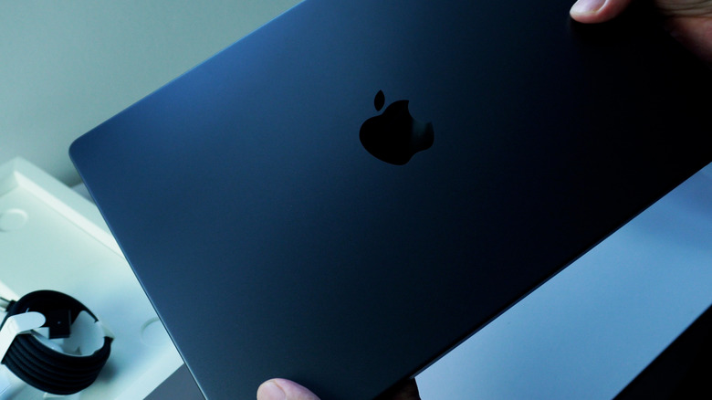 A person holding a MacBook