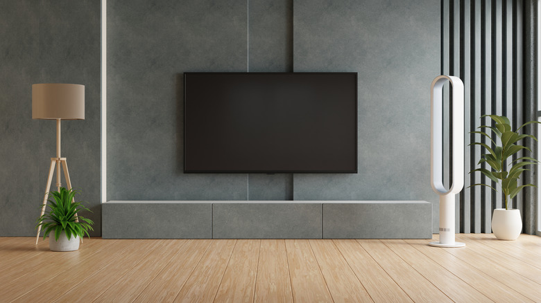 Modern living room with TV, stylish fan, and indoor plants