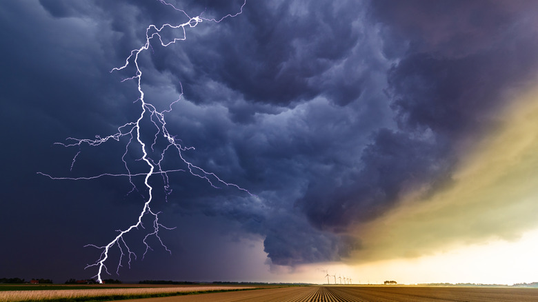 lightning strikes from storm clouds to farmlands