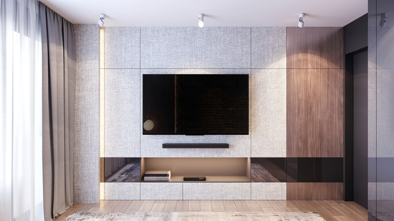 Television mounted on a living room wall with the screen blank.