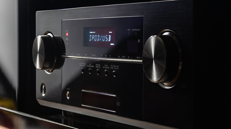 An AV receiver placed in an entertainment center.