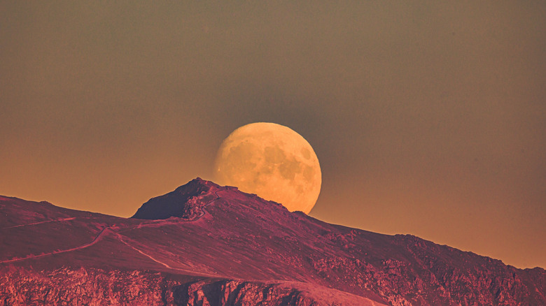 A supermoon rising above the mountains.