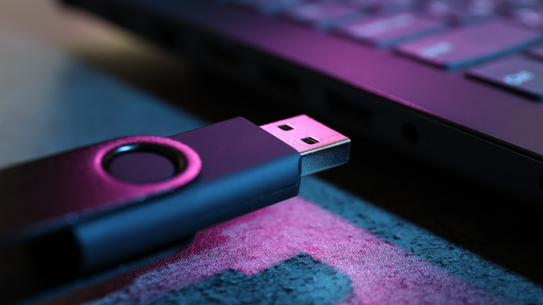 USB flash drive being plugged into laptop USB port.