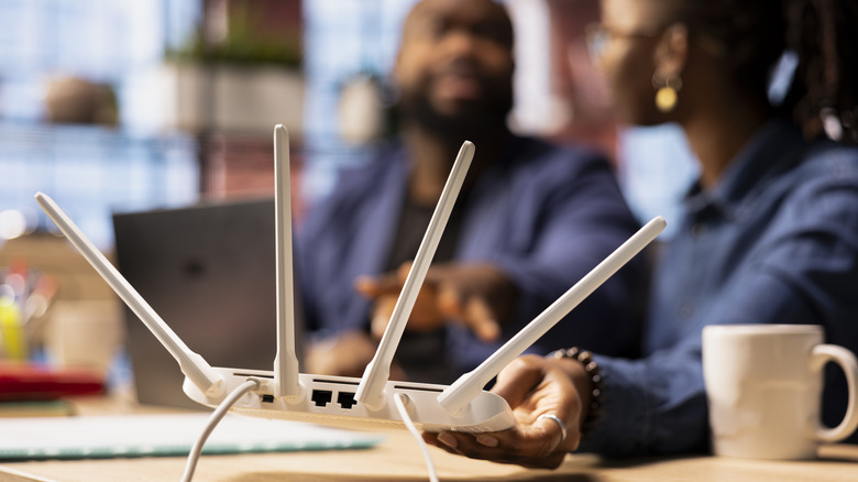 Wireless router in the foreground with a family in the background.