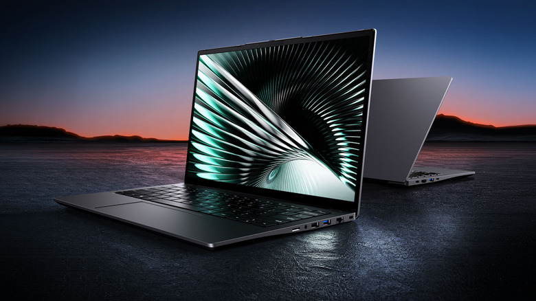 Two Chuwi UniBook laptop computers back-to-back against a darkened land and sea background.