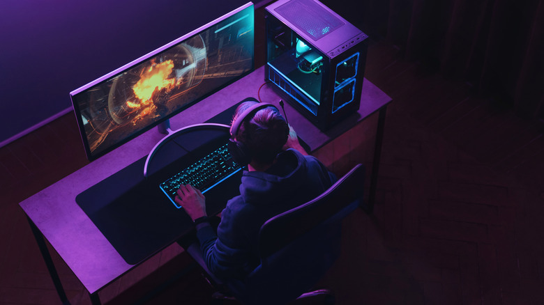 Person gaming in a dark neon-lit room