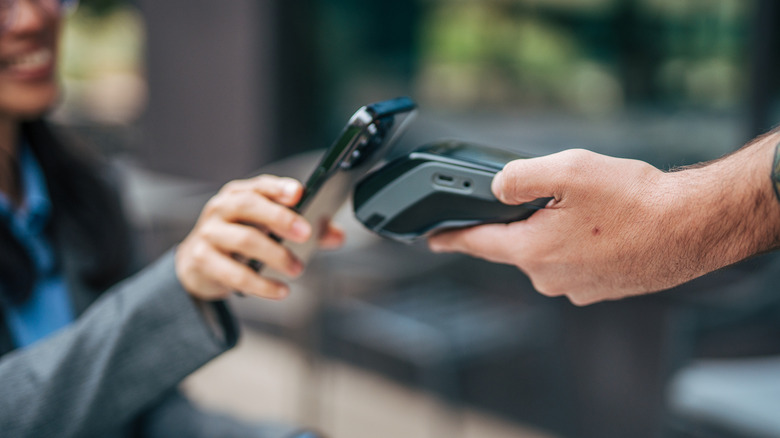 Person using tap to pay with a smartphone.