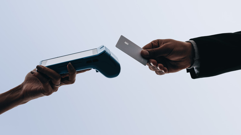 Person using tap to pay with credit card.