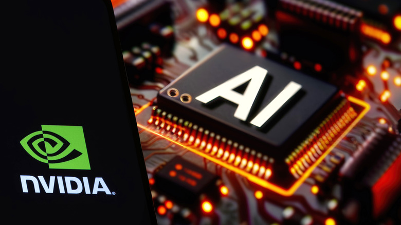 Nvidia logo held in front of computer processor with "AI" displayed on it.