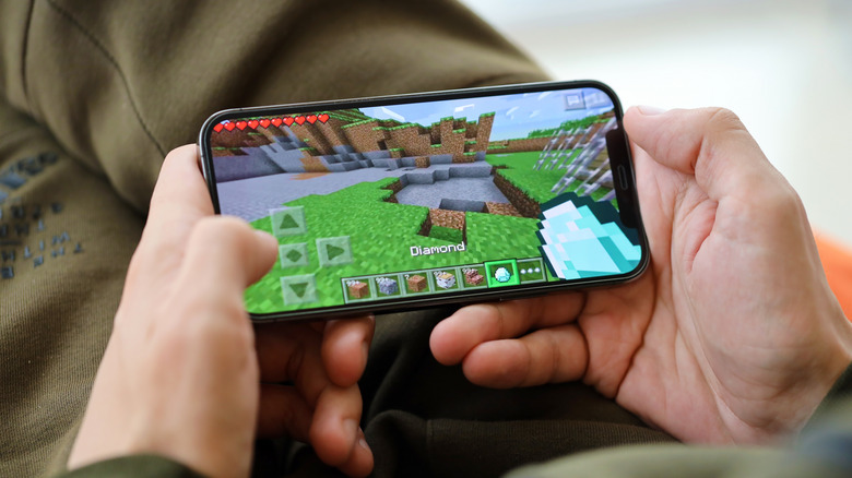 a person playing Minecraft on an iPhone