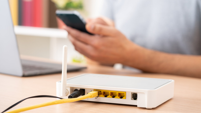 a man uses his phone near a home router