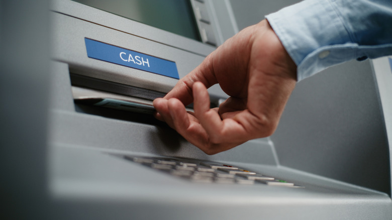 a person getting cash from an ATM machine