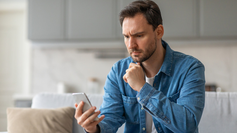 a concerned man looking at his phone