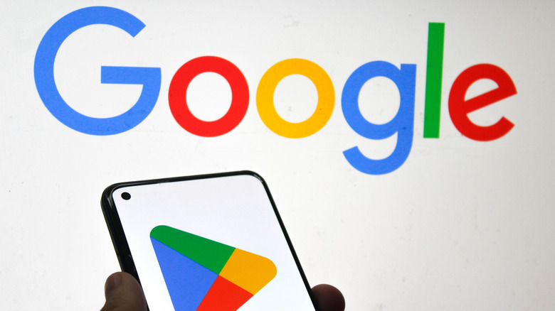 Google logo in the background with the Google Play Store symbol displayed on the phone