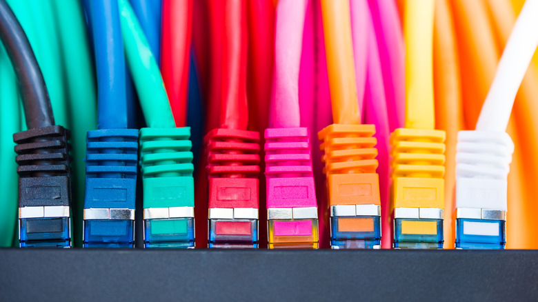 Colorful Ethernet cables plugged into an endpoint with hues ranging from blue to red to orange.