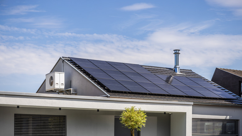 Solar panels on a roof with  and air conditioner and split inverter system visible.